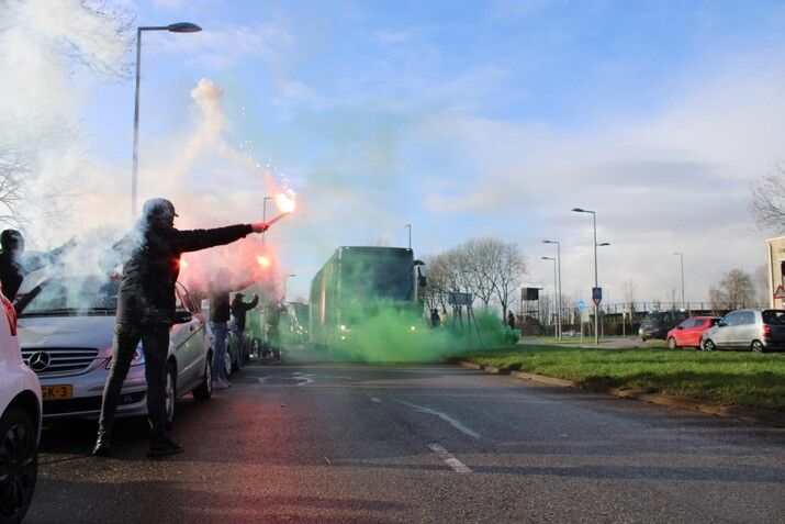 Supporters zwaaien spelersbus uit richting Klassieker