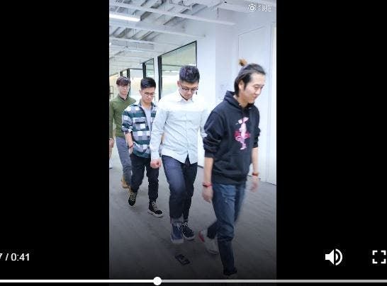 Seven young men line up to take their turns in stepping on this device