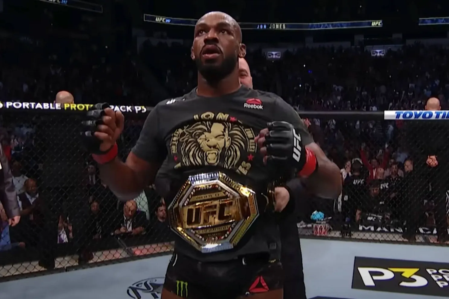 Jon Jones krijgt de UFC wereld titel omgehangen door vechtbaas Dana White.