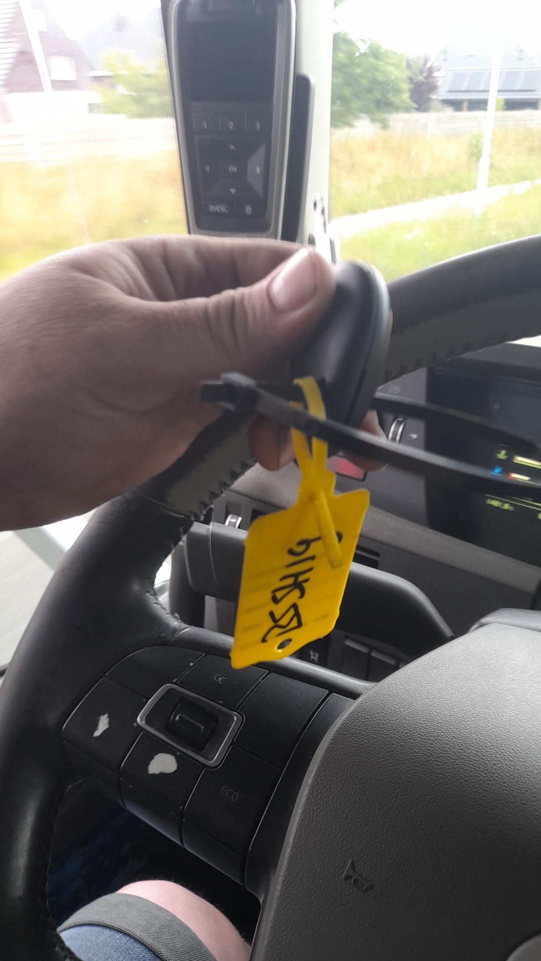 Iemand wil vlaggen weghalen, chauffeur pakt sleutel en rijdt verder