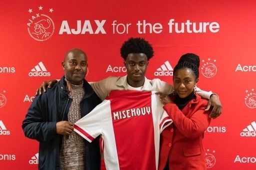 Gabriël na zijn eerste contractondertekening bij Ajax met vader Johnny en moeder Francisca.
