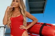 Voormalige Baywatch-babe Carmen Electra trekt een roze bikini aan en duwt haar 'derrière' onder onze neus