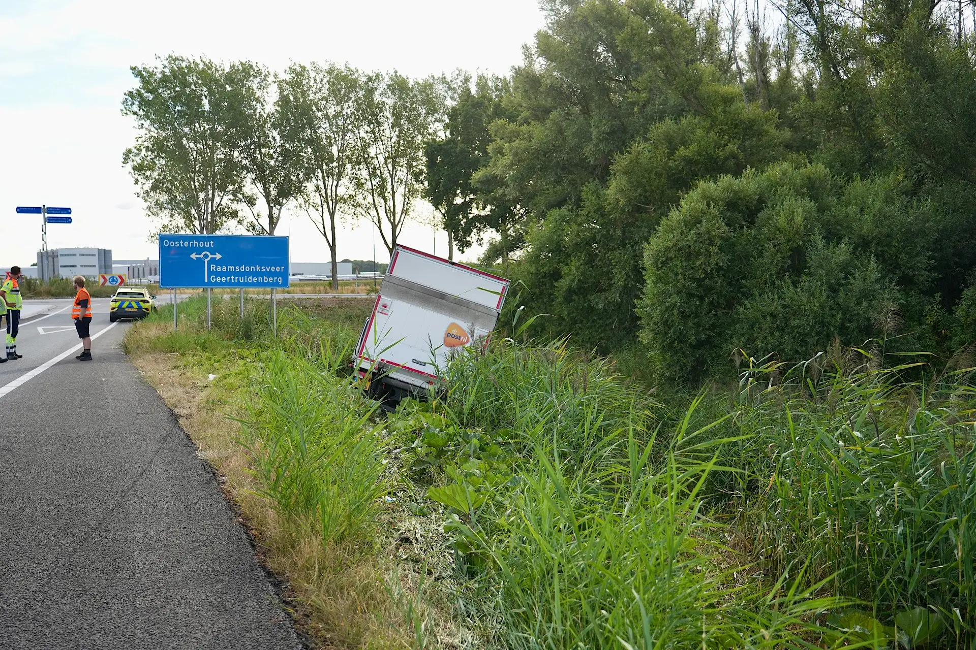 PostNL vrachtwagen belandt naast A59 bij Oosterhout