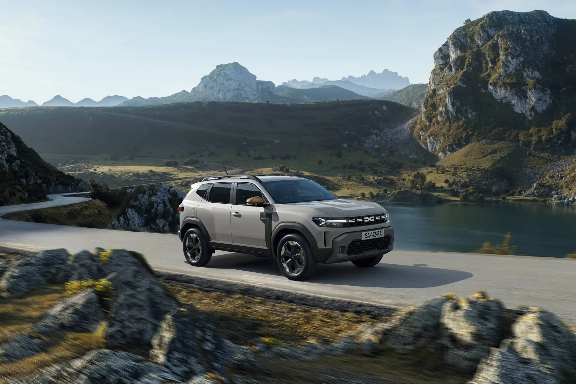 dacia duster percorre una strada ricca di curve in mezzo ad uno sterrato