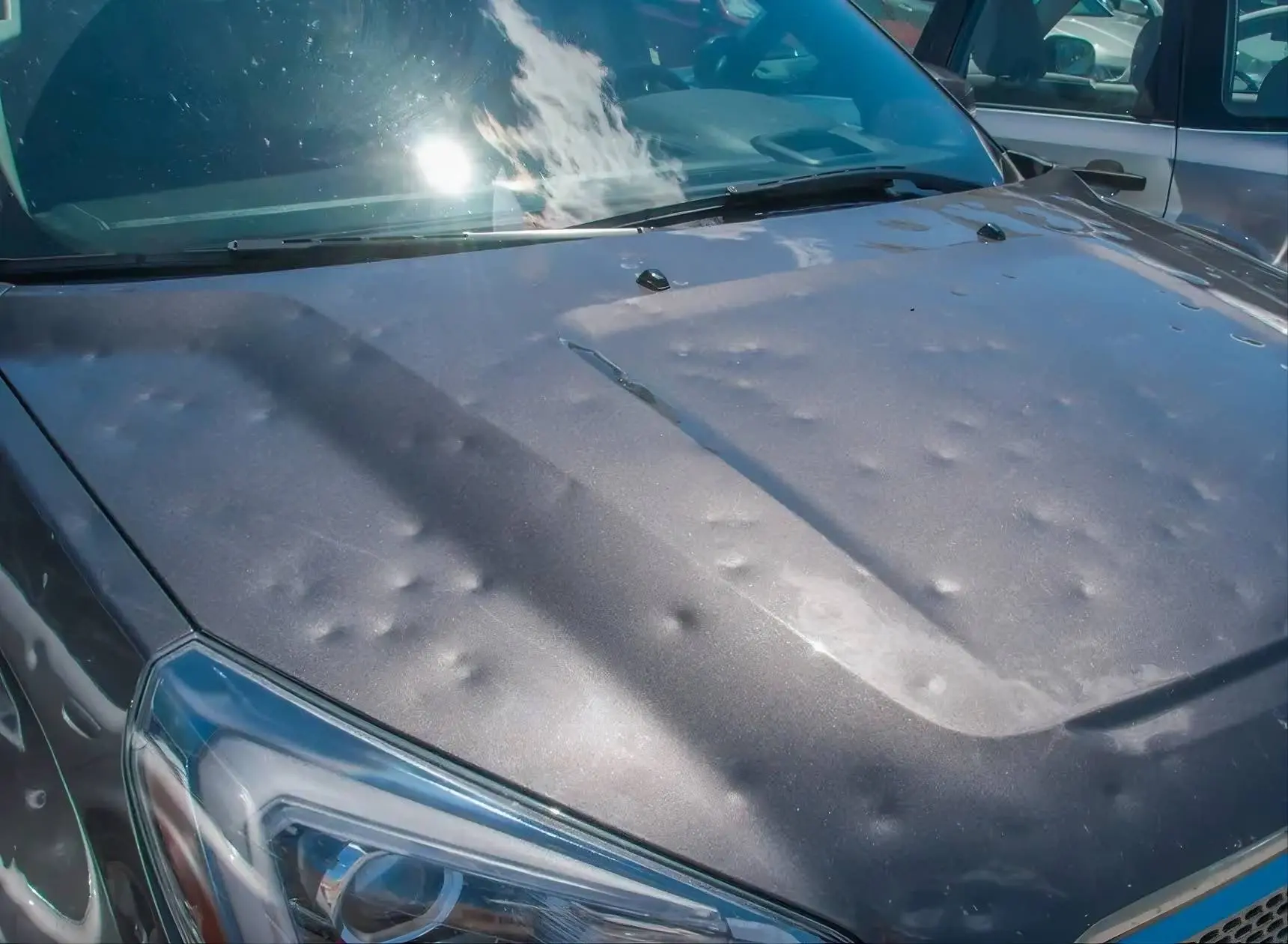 Nell'immagine si vede un'auto colpita dalla grandine