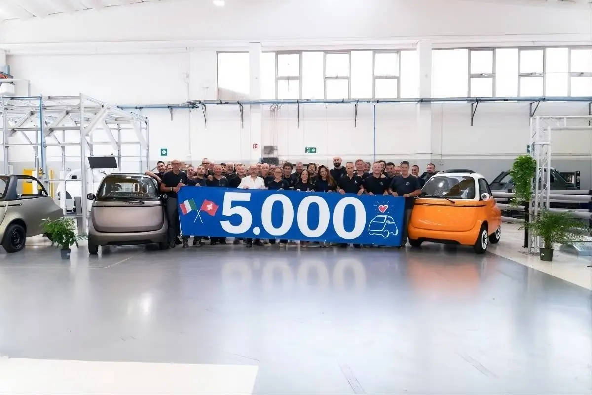 due microlino con in mezzo un cartello che celebra le 5.000 unità prodotte ad oggi