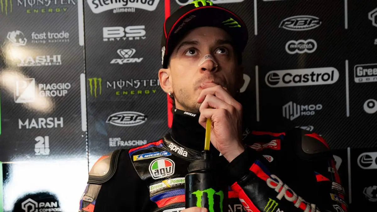 Marco Bezzecchi pilota Aprilia MotoGP beve dalla borraccia nera Monster mentre è seduto nel box a Phillip Island