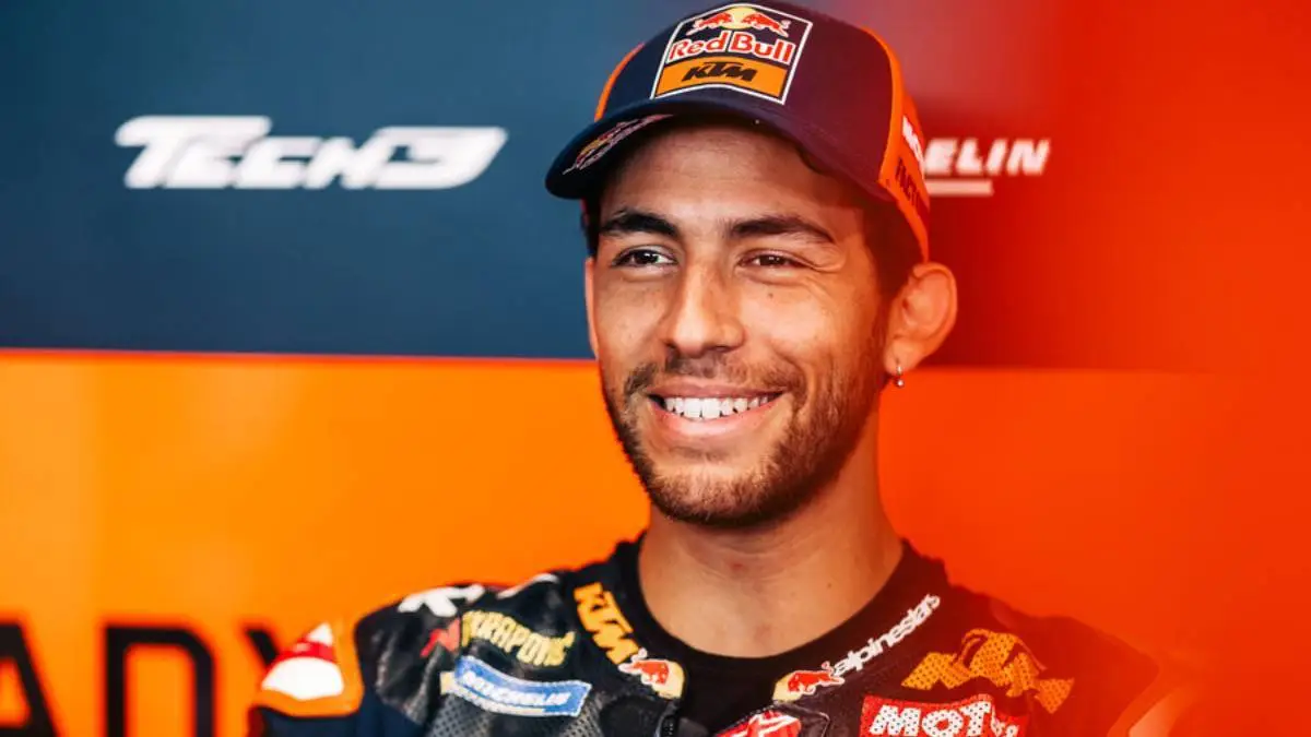 Enea Bastiani sorride mentre è seduto nel box del team KTM Tech3 MotoGP
