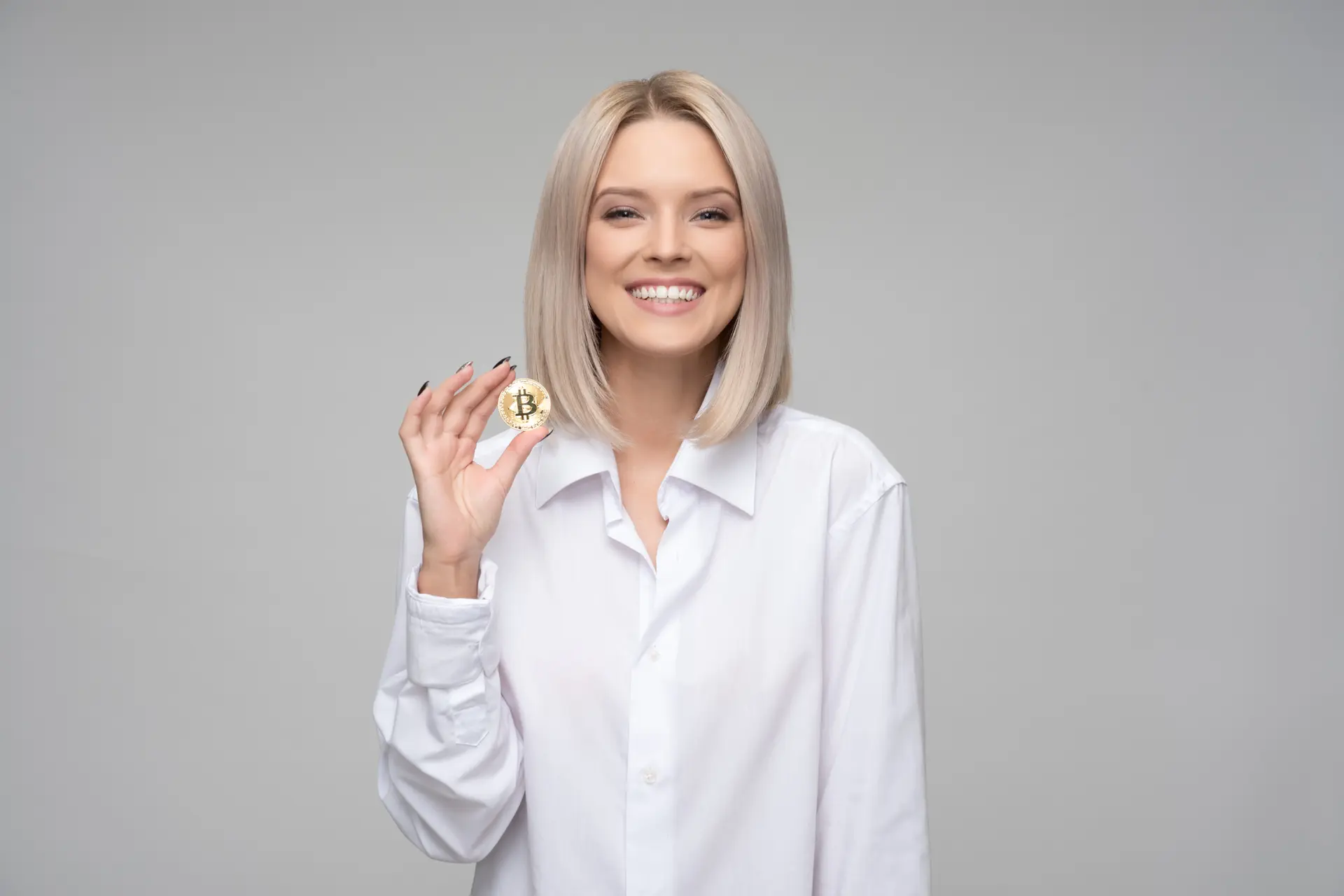 canva women wearing white long sleeved collared shirt holding bitcoin
