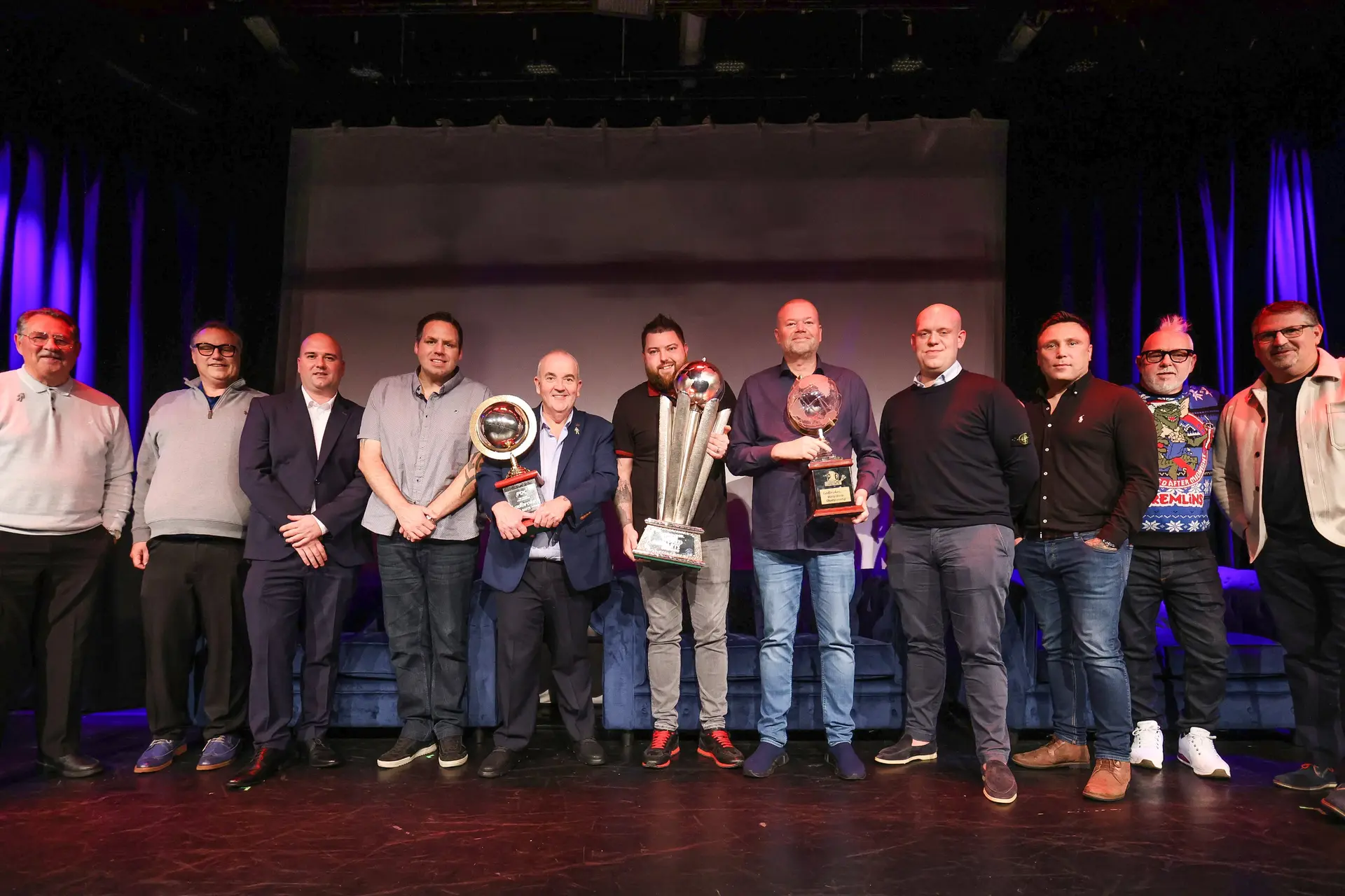 Unieke foto met alle PDC wereldkampioenen op één podium voorafgaand aan WK 2024