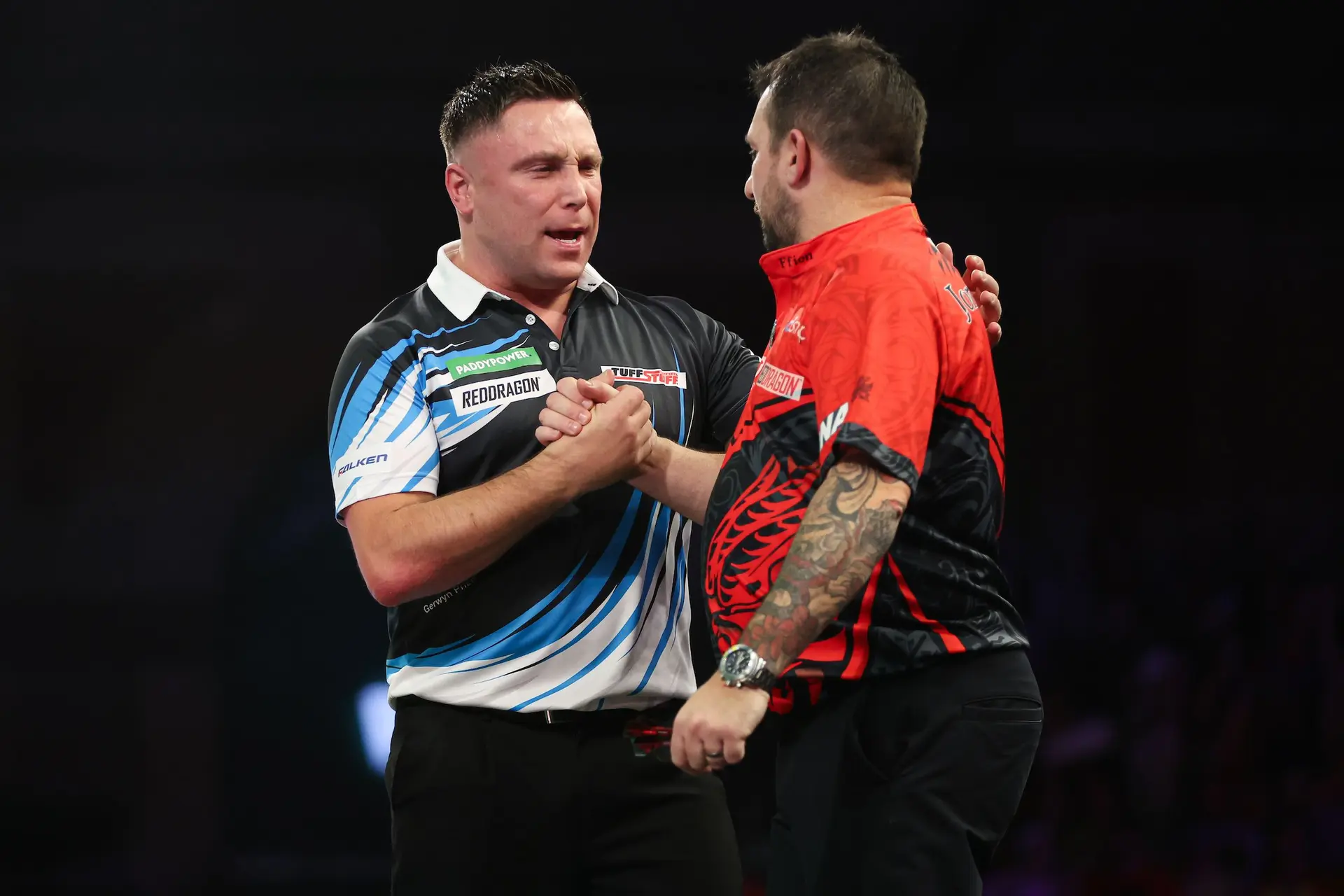 Gerwyn Price and Jonny Clayton shake hands on stage.