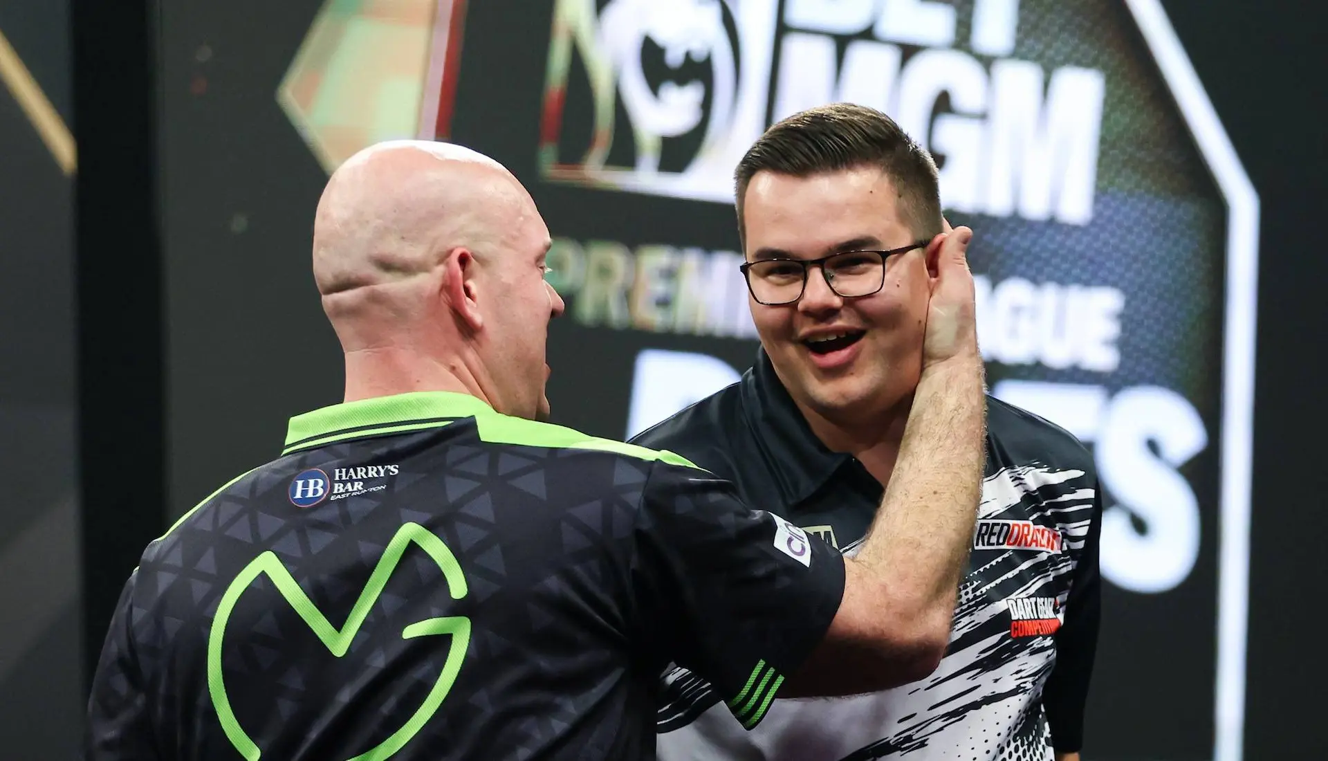 Michael van Gerwen &amp;amp;amp; Gian van Veen embrace on stage during the Premier League Darts.
