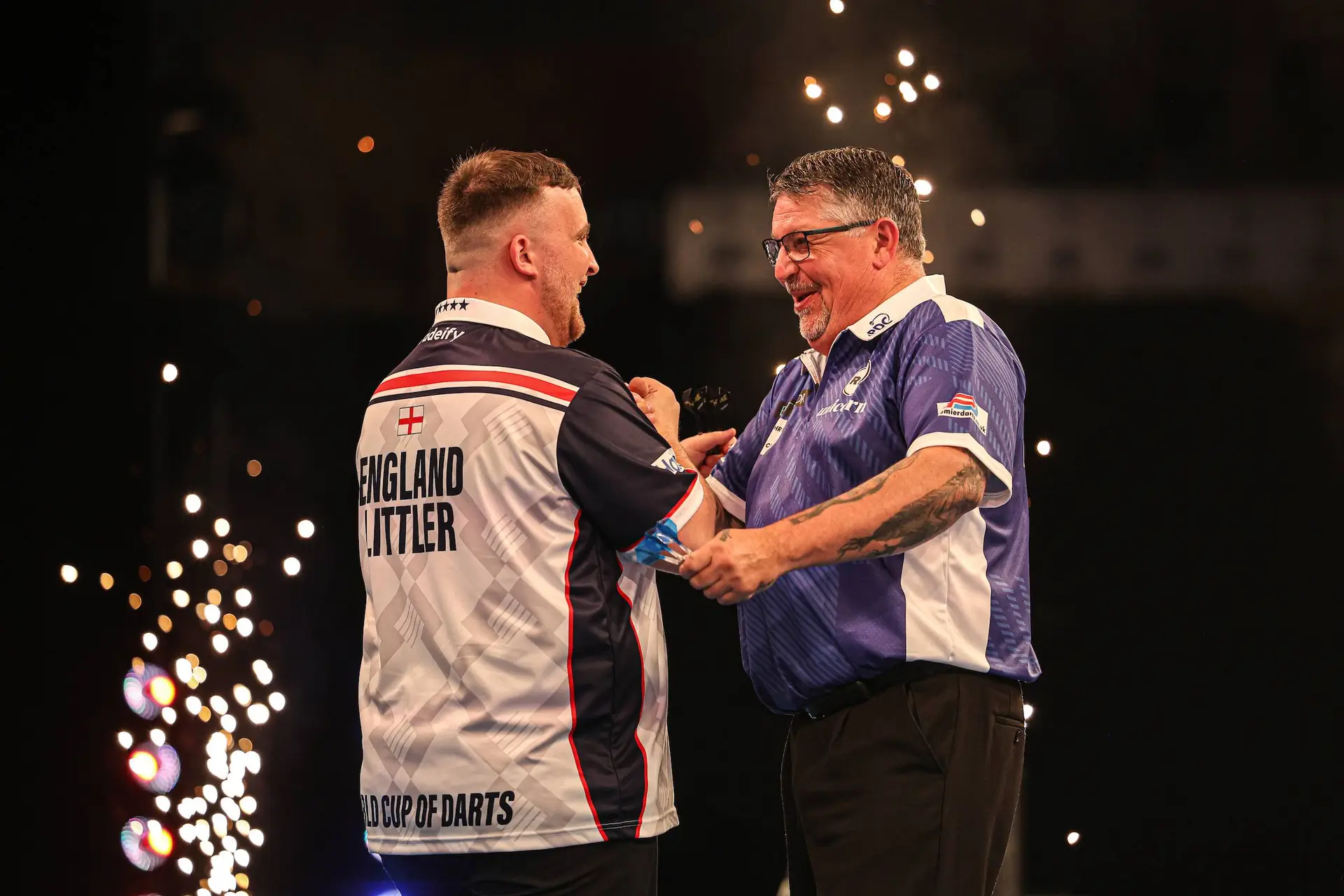 Luke Littler and Gary Anderson shake hands after England knock Scotland out of the 2026 World Cup of Darts