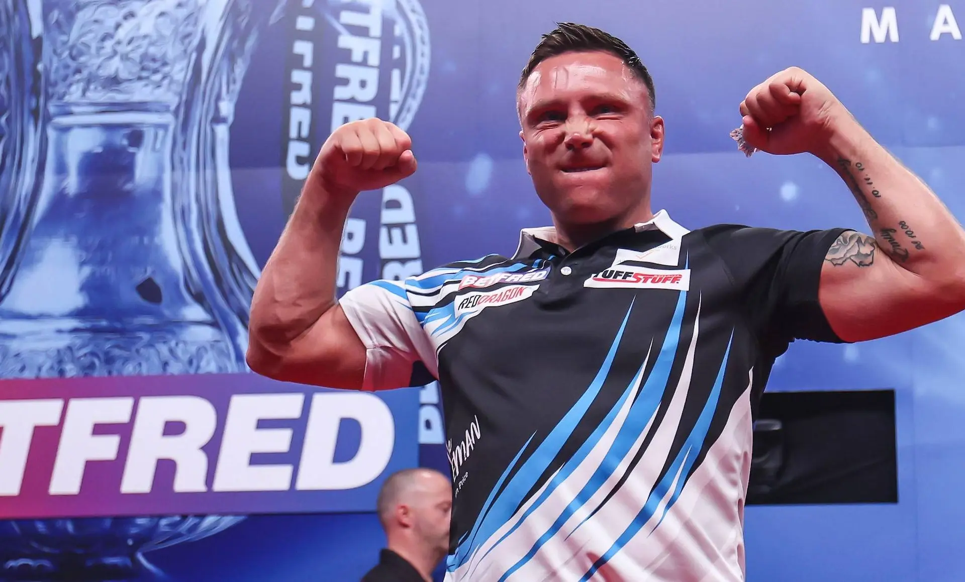 Gerwyn Price flexes his muscles on stage