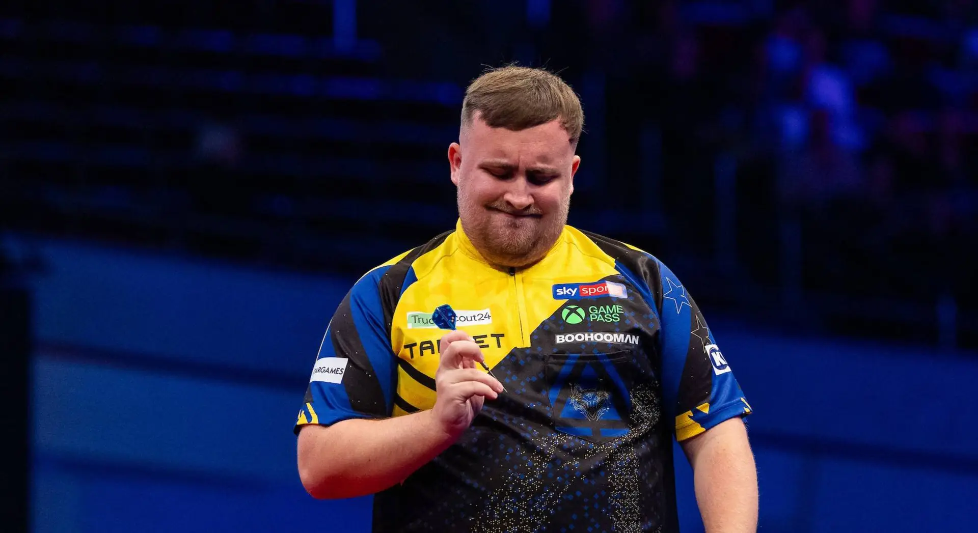 Luke Littler examining dart