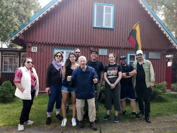 Helmutas Kubillus (viduryje su lazdomis) prie išlikusio Kubillus šeimos namo Preiloje su vaikais ir anūkais 2025-aisiais metais / R. Meyer nuotr.
