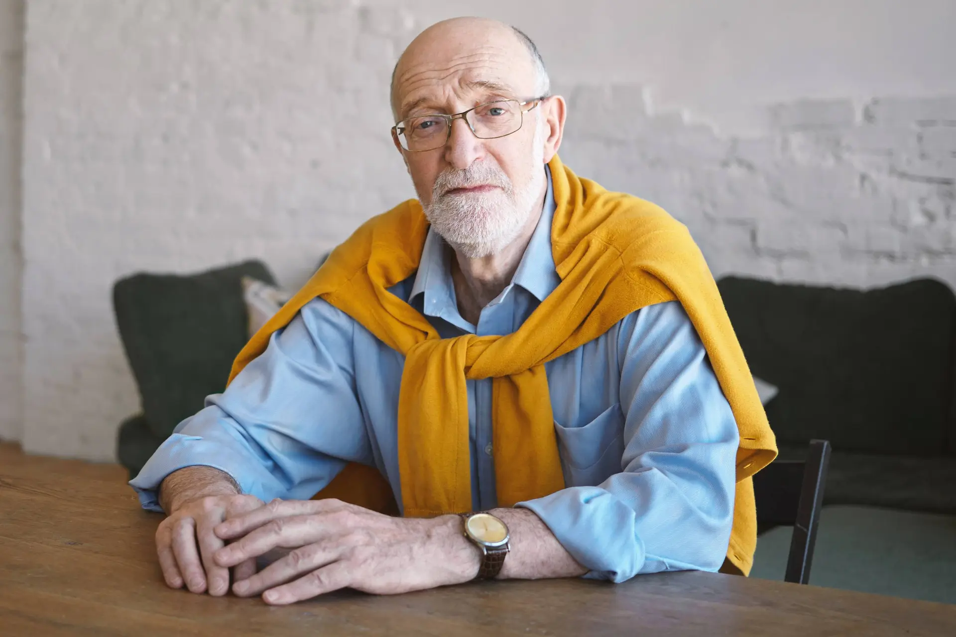 picture confident successful attractive businessman his sixties sitting wooden desk modern office interior having serious facial expression people lifestyle aging business fashion