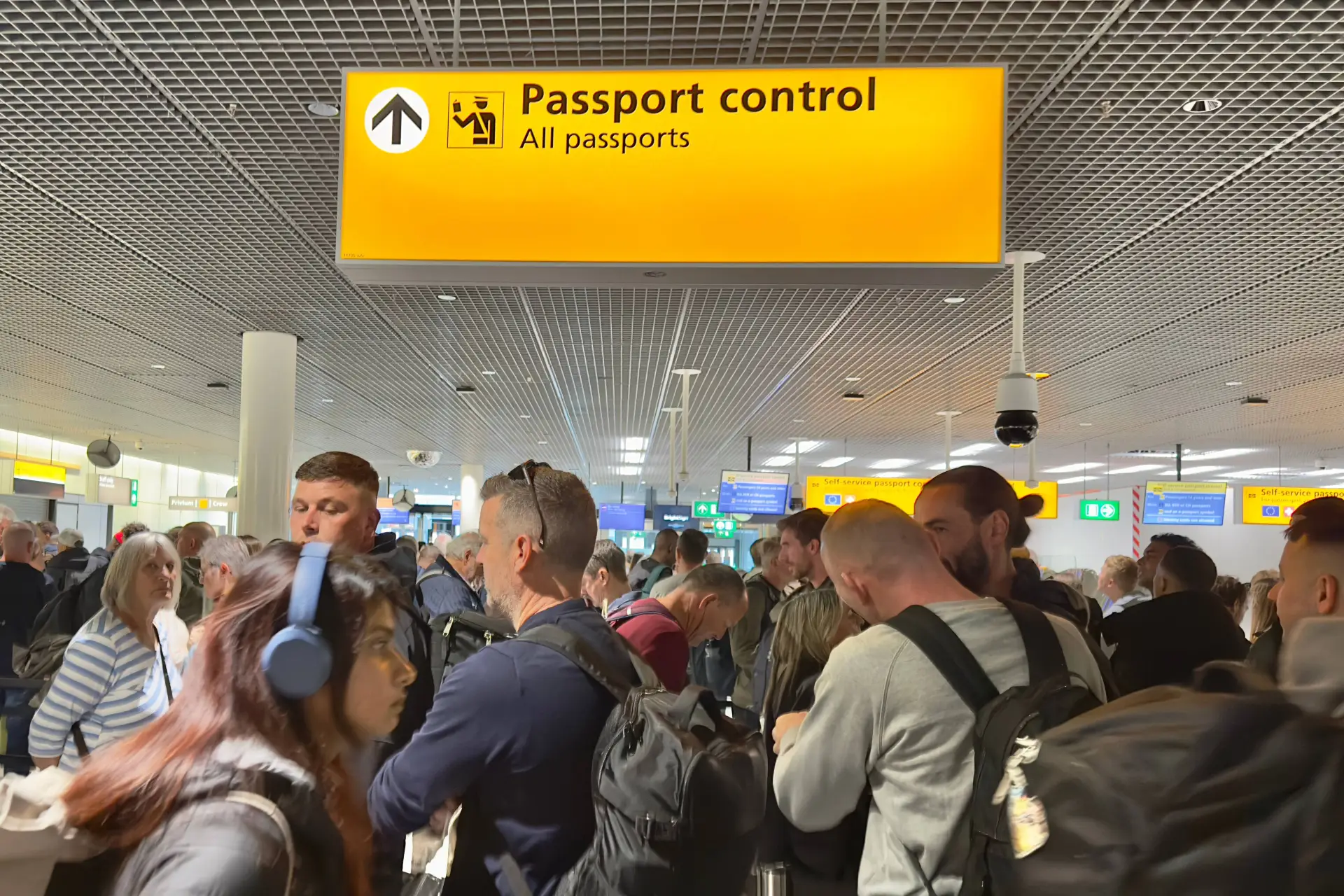 Lange rij reizigers bij de grenscontrole op Schiphol, over de wachttijden door het Europese EES-systeem