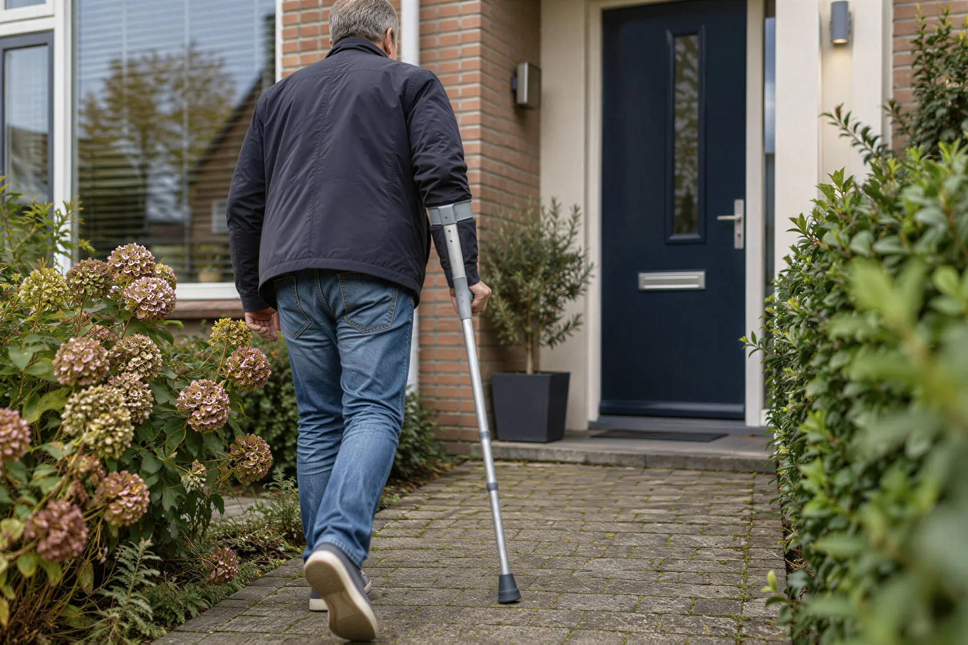 Illustratie van een man die tijdens zijn herstel met een kruk naar huis loopt.