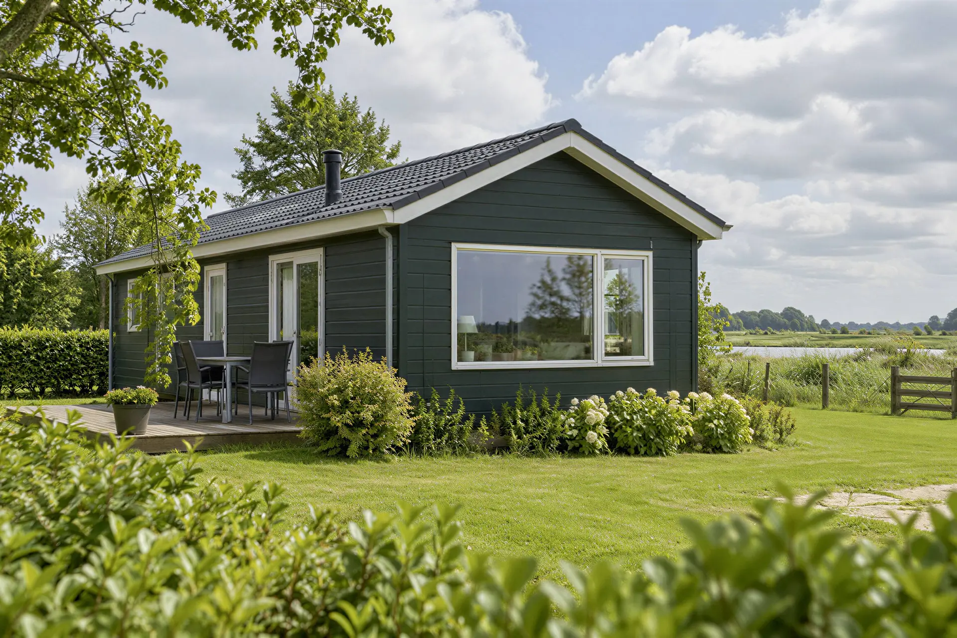 Vrijstaande recreatiewoning in een groen Noord-Nederlands landschap.