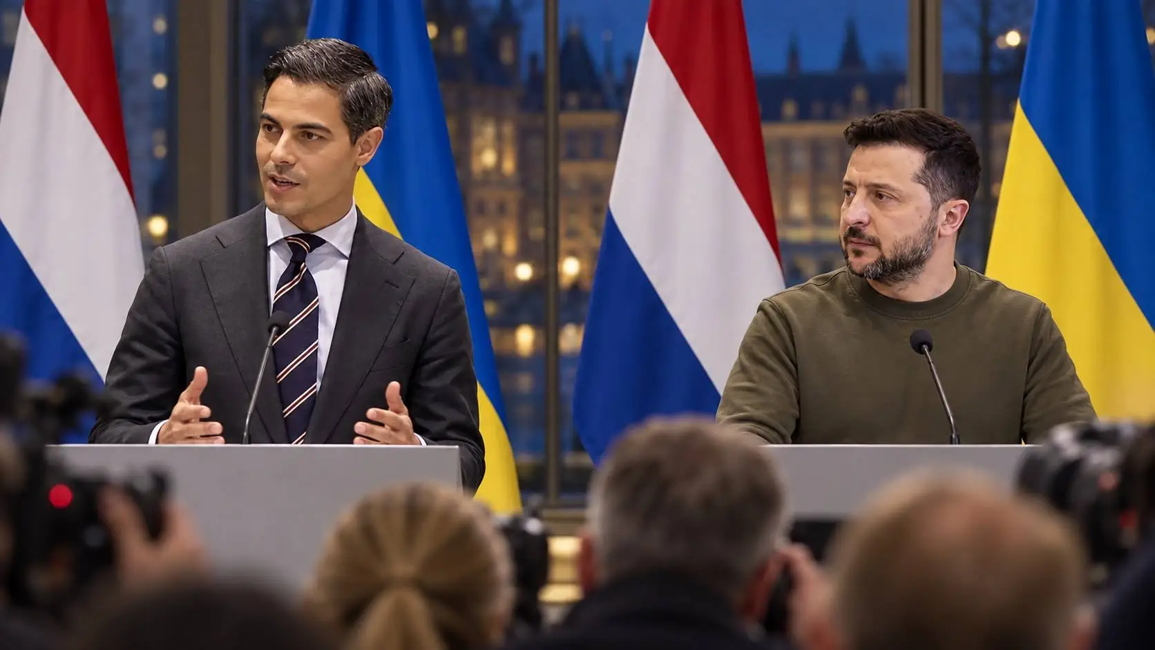 Jetten spreekt op een persconferentie naast Zelensky in groen sweatshirt, voor Nederlandse en Oekraïense vlaggen