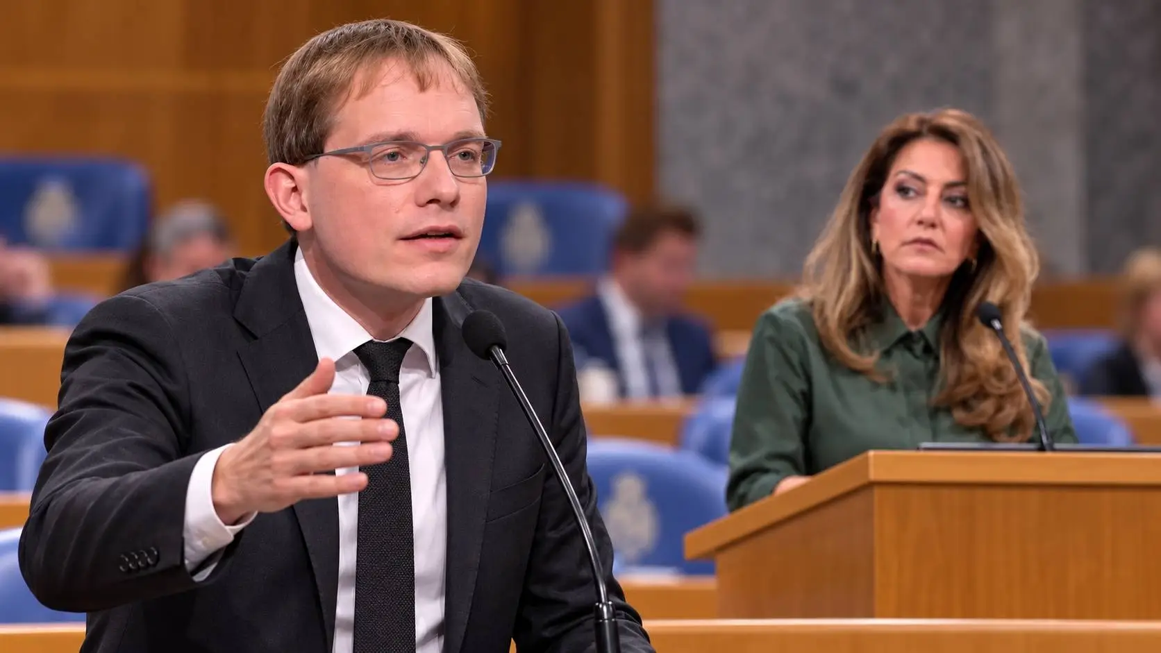 AI-illustratie van Pepijn van Houwelingen bij de interruptiemicrofoon, met Dilan Yeşilgöz achter het spreekgestoelte op de achtergrond.