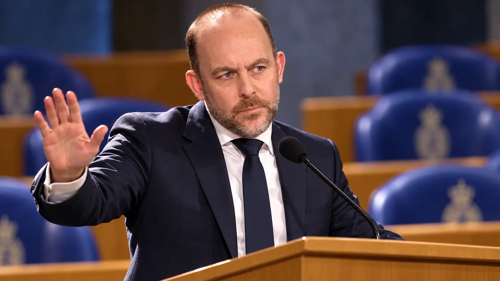 AI-illustratie van minister Bart van den Brink achter het spreekgestoelte in de Tweede Kamer.