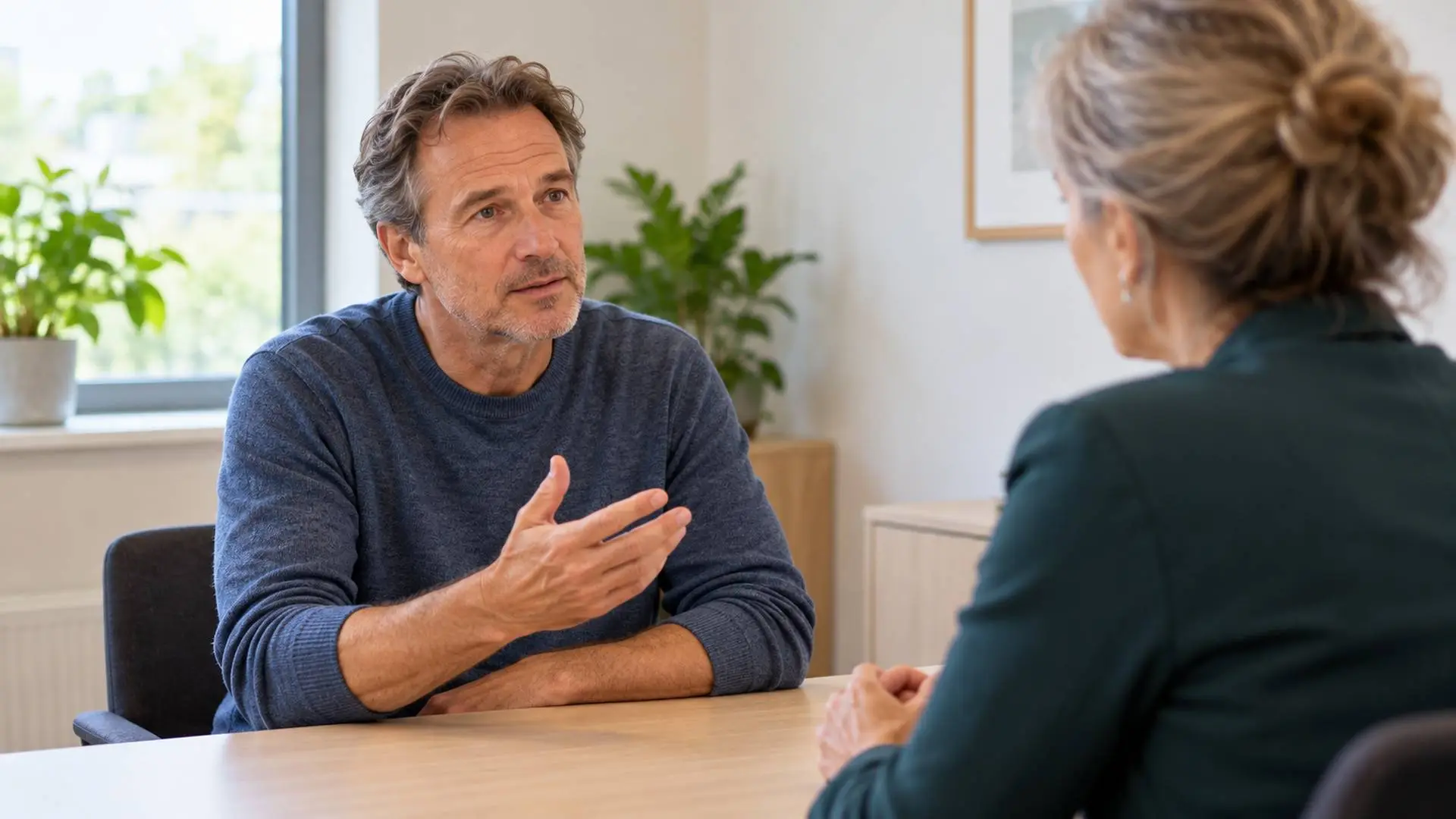 Man bespreekt zijn situatie met een arts in een spreekkamer.