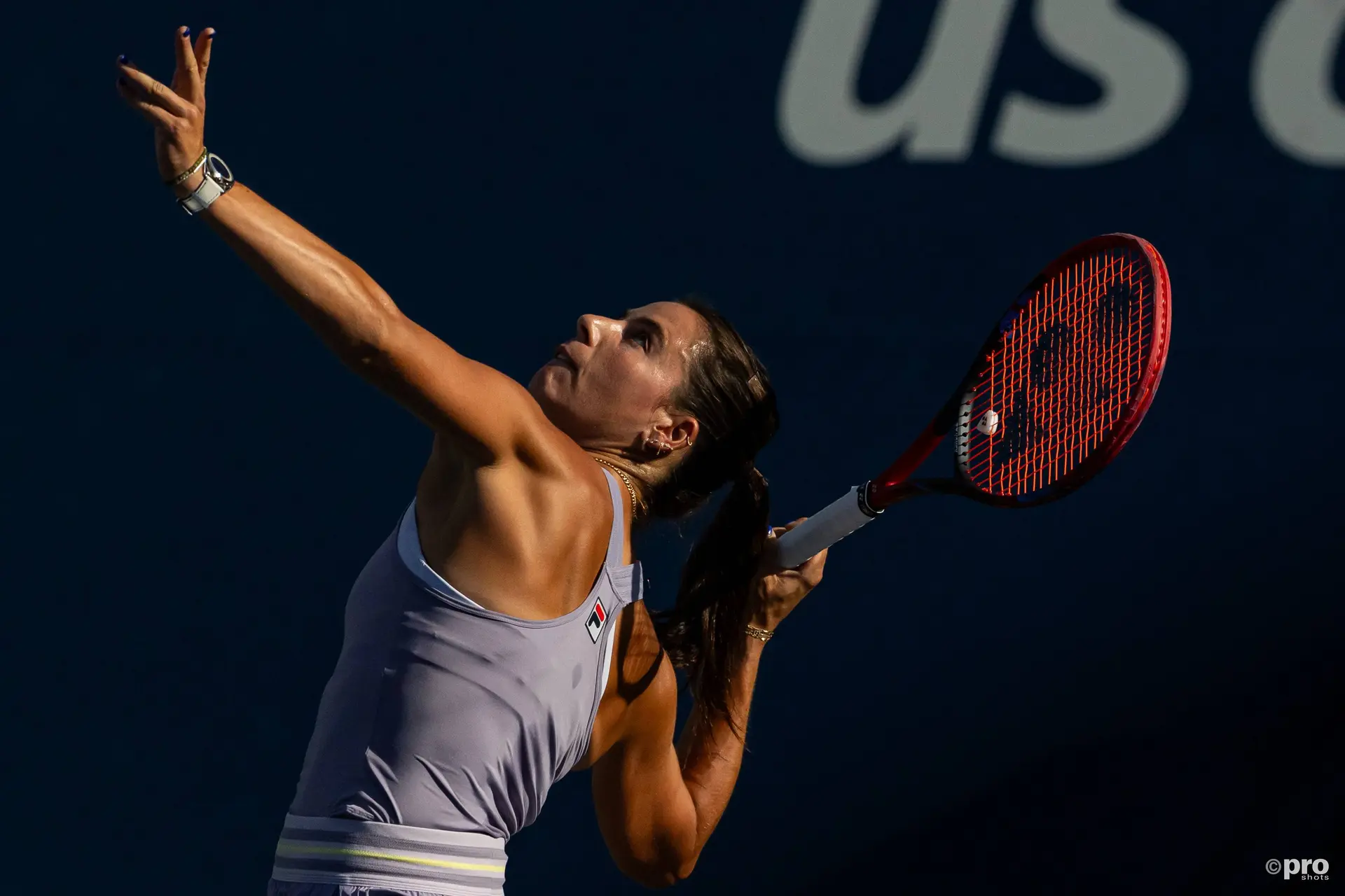 Emma Navarro stares intently at the ball as she prepares to serve.