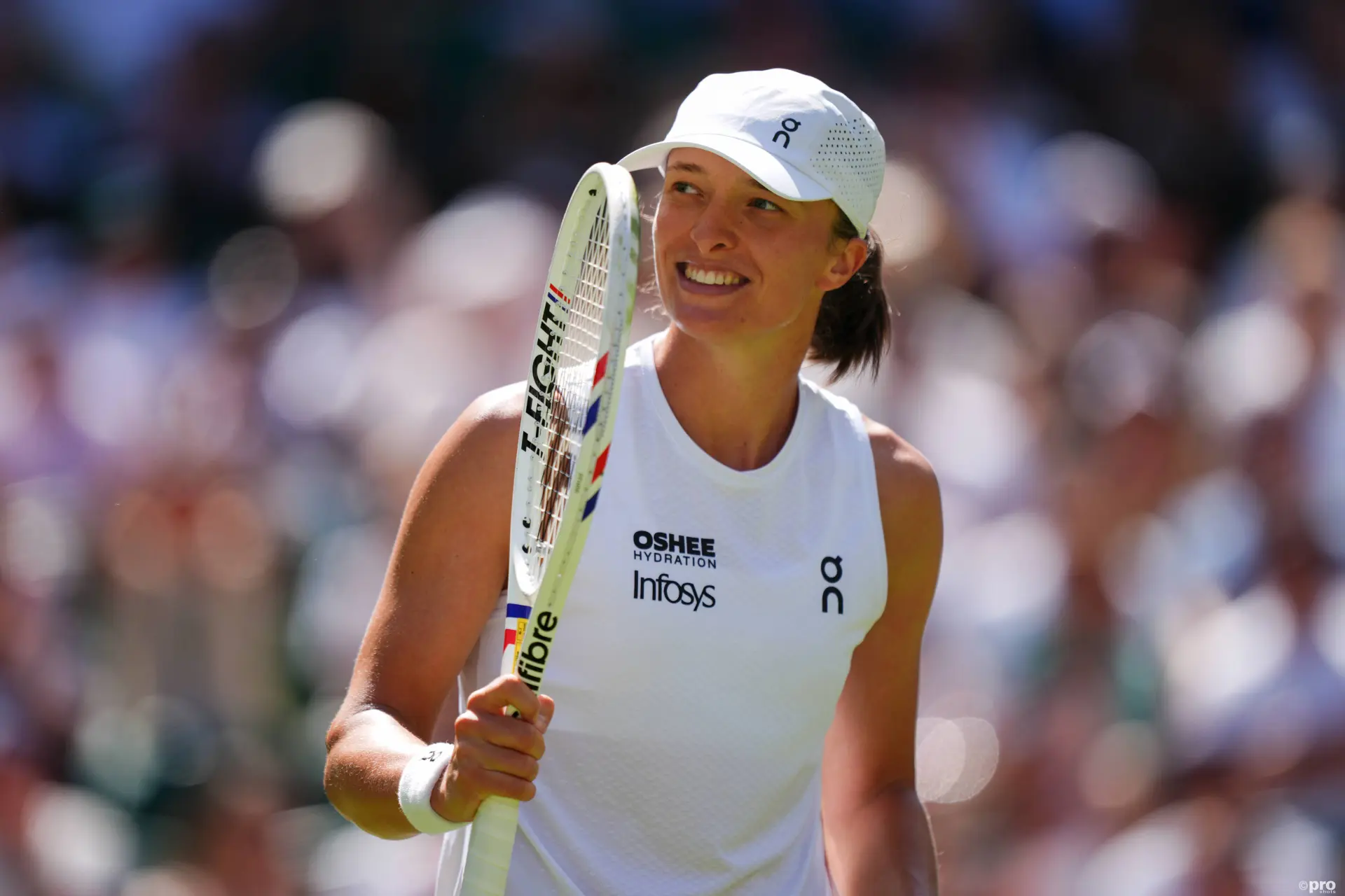 Iga Swiatek holds racquet.