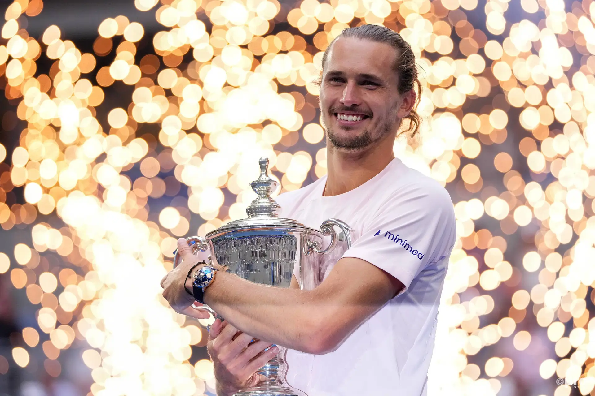 Alexander Zverev holding a trophy while smiling