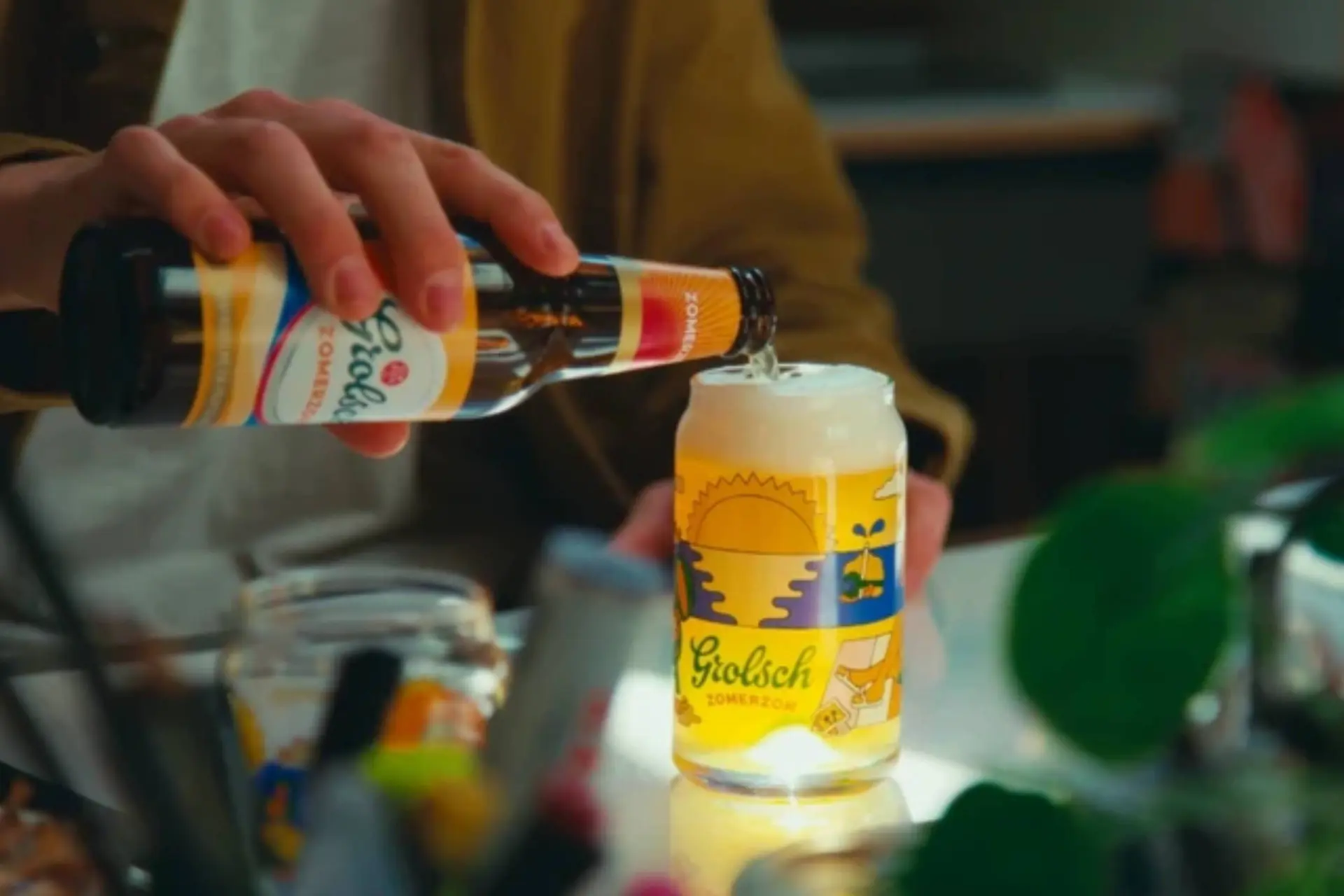 man die grolsch zomerzon in een glas schenkt