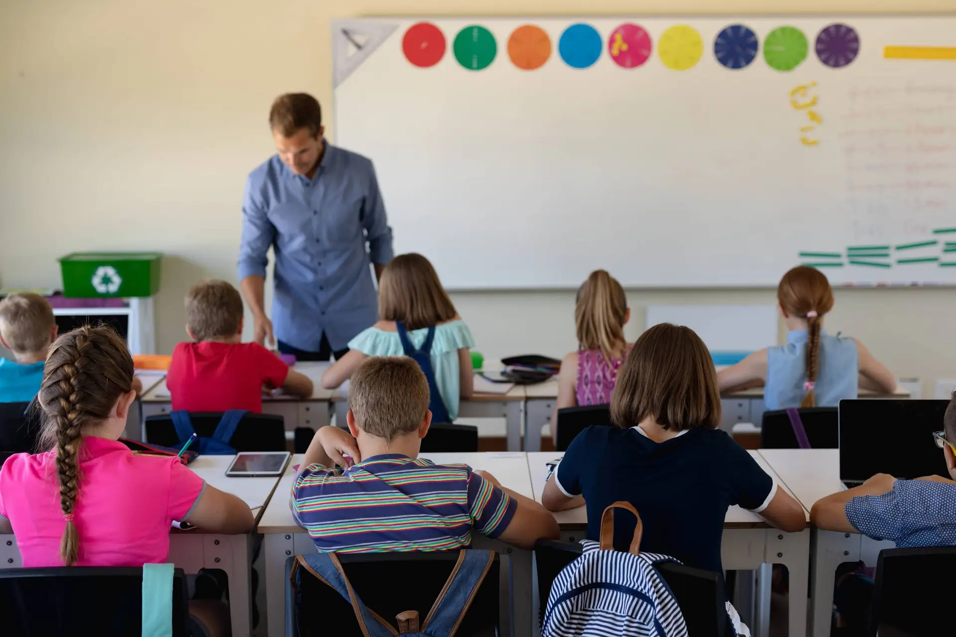 Een leraar geeft les voor een klas met leerlingen aan hun tafels