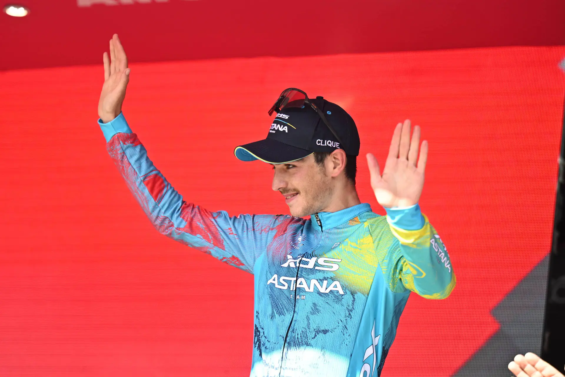 Christian Scaroni viert op het podium met de armen in de lucht