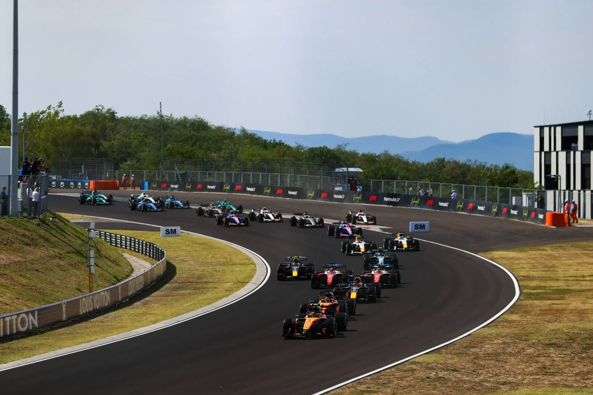 start-grand-prix-hongarije-2026-lando-norris-oscar-piastri-max-verstappen-lewis-hamilton-charles-leclerc-ferrari-mclaren-red-bull-racing-1