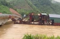 Losgeslagen boten en kraan willen onder brug door na tyfoon Yagi in Vietnam