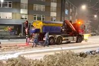 Cafégangers helpen strooiwagen weer op weg die vastzit in de sneeuw