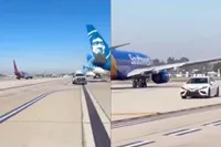 Auto jaagt over startbaan John Wayne Airport tussen de vliegtuigen door