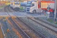 Net geen ramp in België: vrachtwagen klem op spoor, trein mist ’m op centimeters