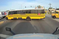 Vrachtwagenchauffeuse flipt de pan uit als ze vol in de ankers moet vanwege schoolbus die door rood rijdt