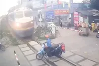 Dwaas op motor denkt nog snel het spoor over te steken met telefoon in z’n hand… en dan komt de trein