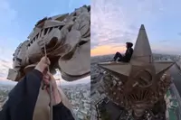 Waaghals beklimt iconische Stalin-wolkenkrabber in Moskou en het uitzicht is bizar
