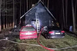 Degė poilsinis pastatas su kubilu ir automobiliai