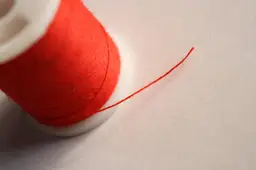 Close-up van een klos rood naaigaren, illustratief beeld bij het Stoffencircus