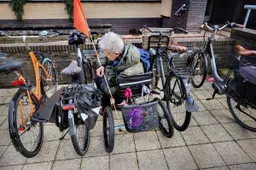 Vrijwilliger Toos van Vliet parkeert haar driewielfiets bij het gemeentehuis in Hilversum. Foto. DigiDaan.