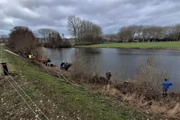 rijwilligers knotten wilgen bij een visvijver in Beuningen