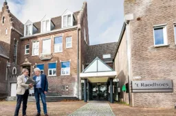 Wethouder Pustjens en wethouder Meuwissen bij het voormalige gemeentehuis in Susteren
