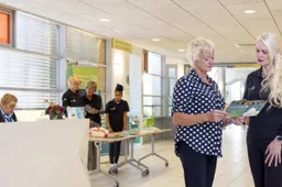vrijwilliger sigrids garden rechts geeft informatie aan een patient