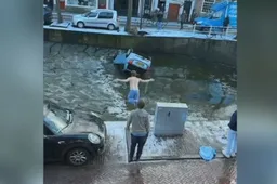 Student springt in gracht en redt vrouw uit te water geraakte auto