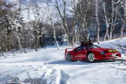 Ontembare Ferrari F40 knalt al driftend door de besneeuwde bossen van Japan